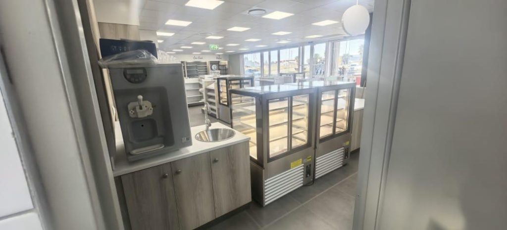 Completed store interior showing shelving, lighting, and electrical installations at Total Creswell Park.