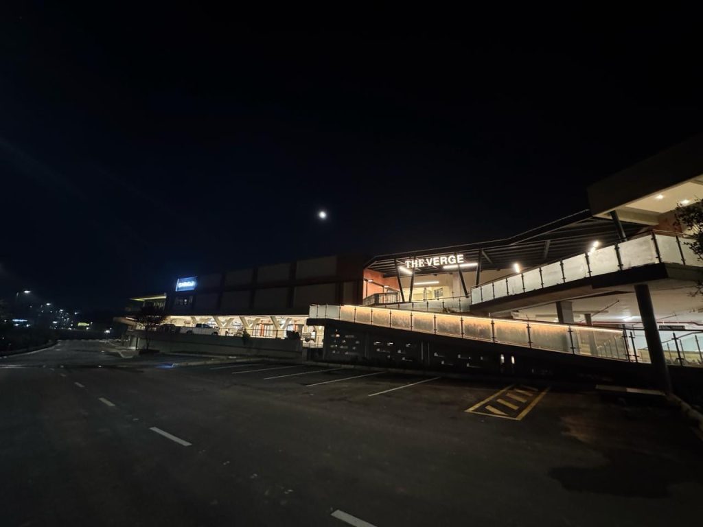 Night view of The Verge Shopping Centre with full exterior lighting.