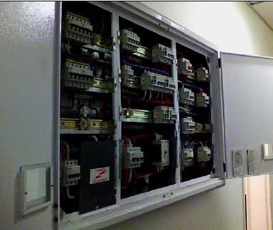 Electrical distribution board with wiring and breakers visible.