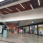 Retail corridor showing stores and shoppers inside Dhlamini Junction