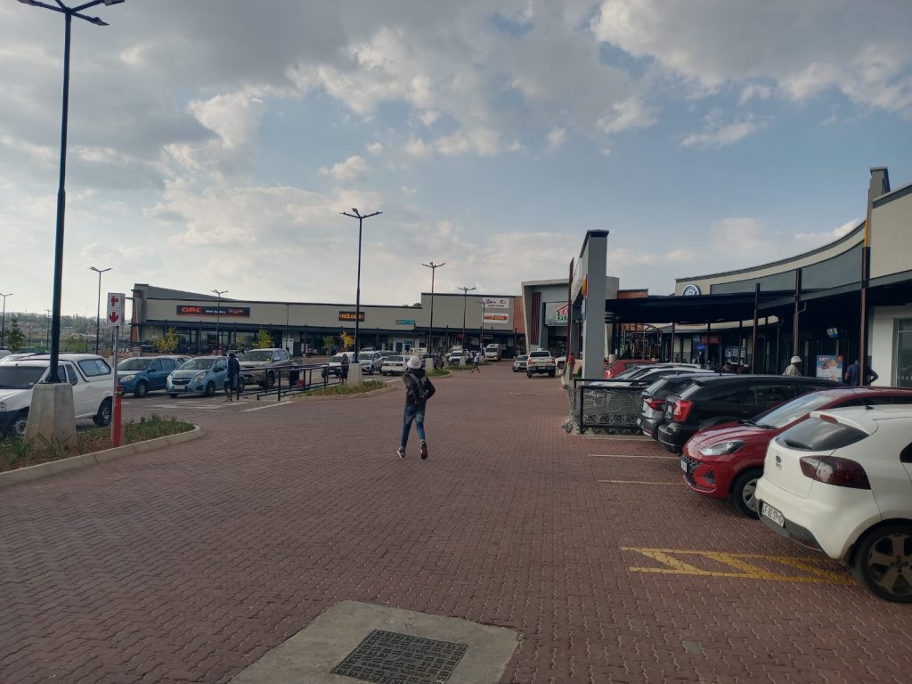 Wide-angle view of Dhlamini Junction showing parking and surrounding buildings